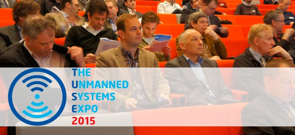 Audience seated in an auditorium during The Unmanned Systems Expo 2015, with a focus on UAV and drone technologies.