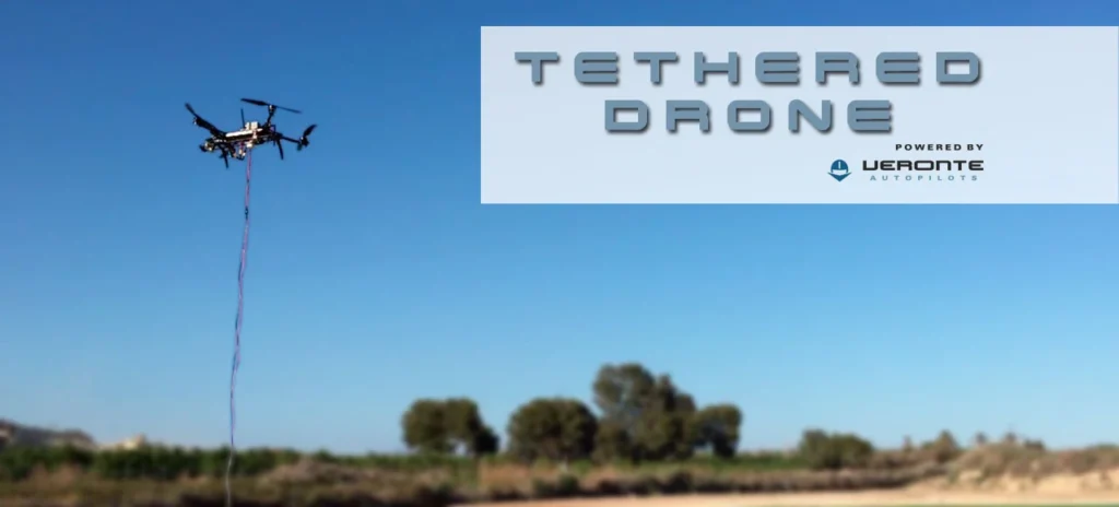 A drone in flight tethered by a cable, demonstrating Veronte's autopilot system under a clear blue sky.