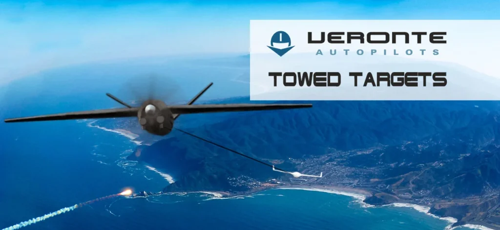 Image of a UAV towing targets over the ocean with mountains in the background.