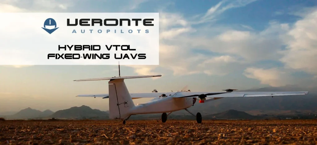 Hybrid VTOL fixed-wing UAV on ground with Veronte autopilots logo and mountains in background.