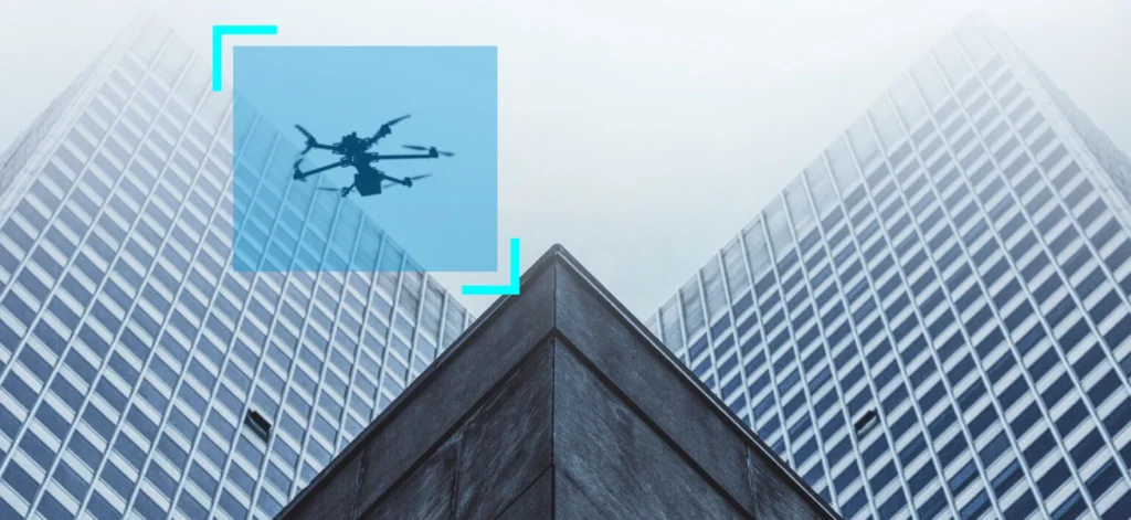 Drone equipped with artificial vision technology flying between skyscrapers, illustrating the application of computer vision in UAVs for navigation and obstacle avoidance.