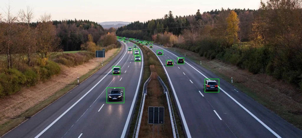 Drone image showing a highway with cars outlined for moving object detection.