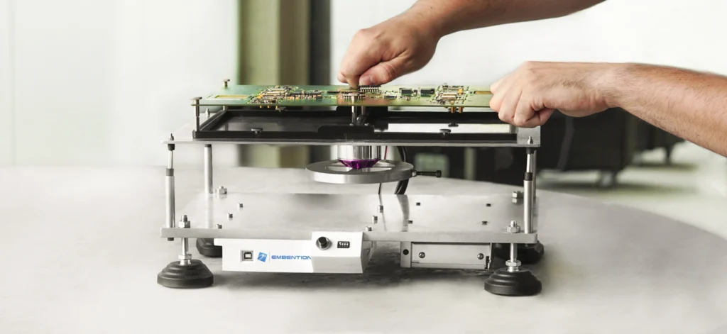 Technician performing Environmental Stress Screening (ESS) on a Veronte Autopilot circuit board using specialized equipment to ensure durability and reliability.
