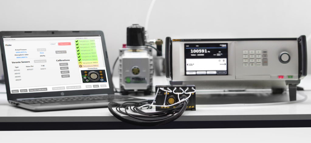 Calibration setup for Veronte Autopilot pressure sensors, featuring a laptop with calibration software, a pressure controller, and a reference module to ensure precise and accurate sensor measurements.