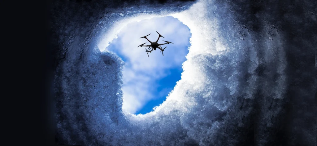 Drone flying above snow-covered terrain for search and rescue operations.