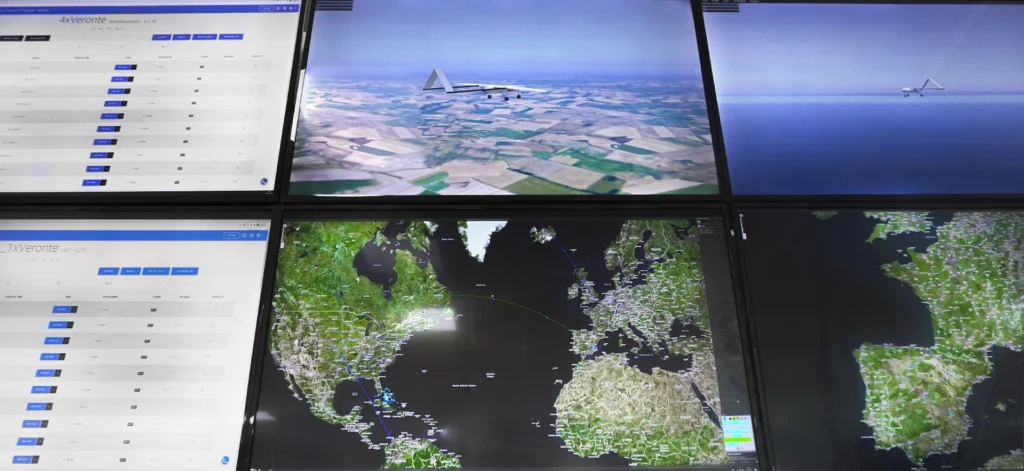 Control room with multiple screens displaying UAV flight simulations and real-time data analytics.