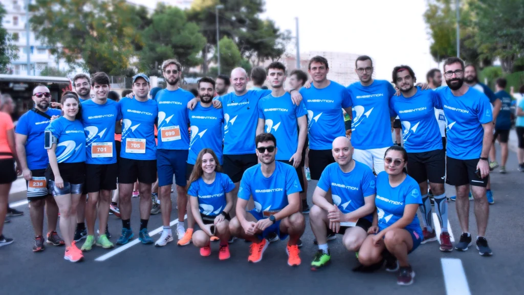 Embention's employees wearing blue t-shirts and standing on a road for a race