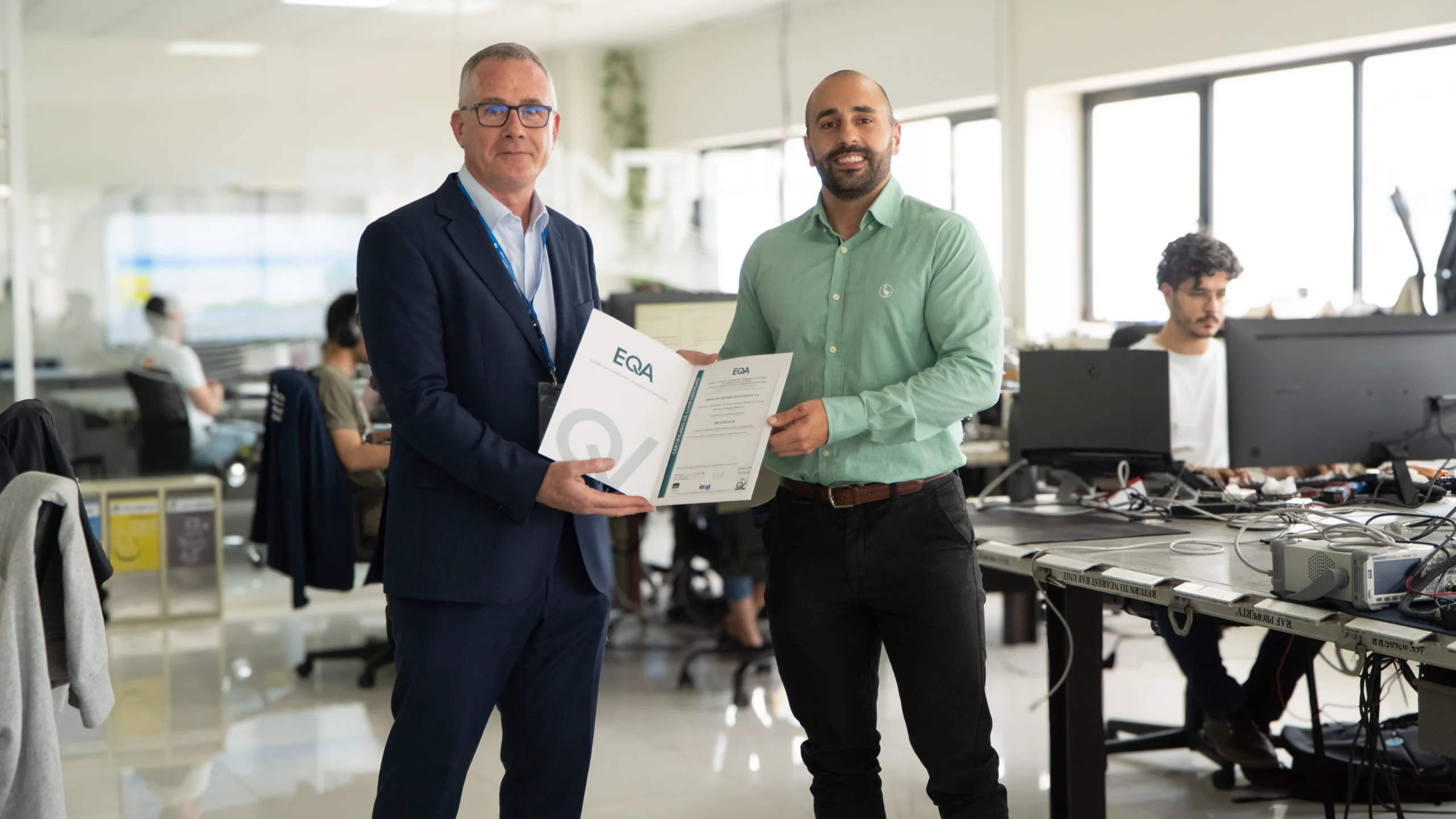 Person from the Quality Department receiving an EN9100 certificate at Embention's offices.