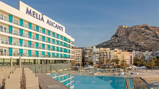 Melia Melia Alicante hotel with an infinity pool overlooking the city and a mountain.