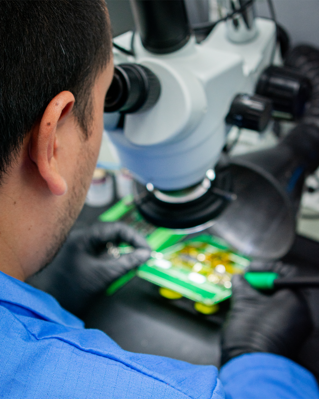 Lab-Prod Trabajador de laboratorio de producción observa un circuito a través del microscopio.